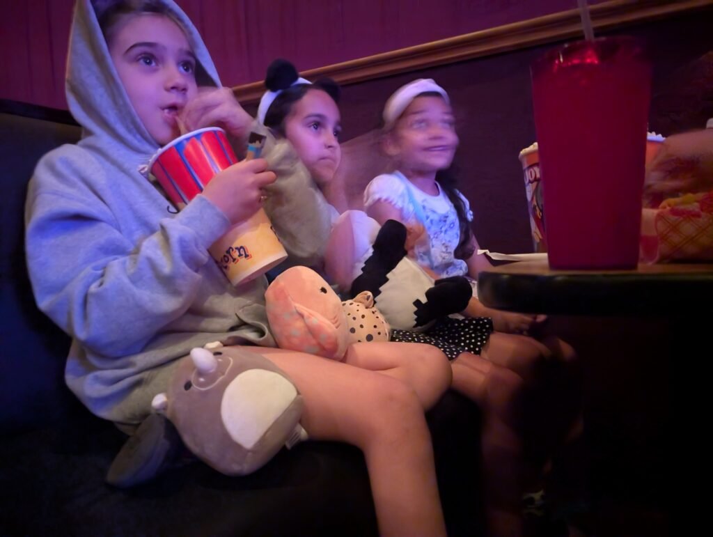 3 kiddos watch a movie at the aloma cinema grille.